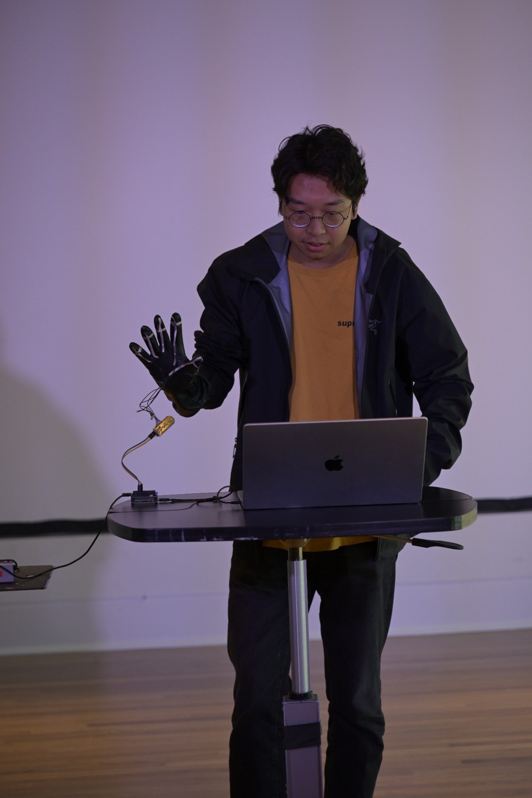 Participant demonstrating a wearable sound instrument at a laptop
