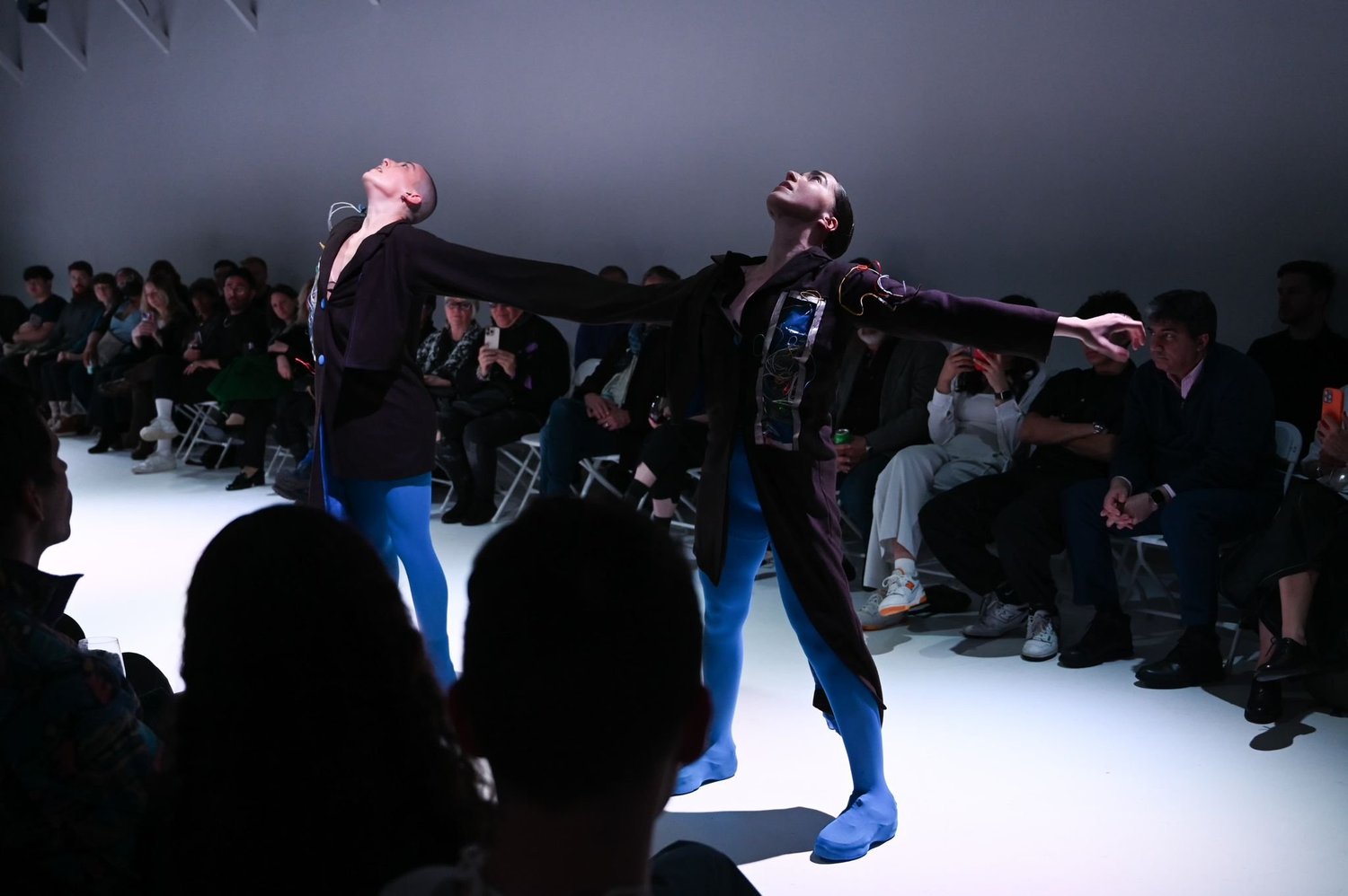 Two performers connected through movement and garments.