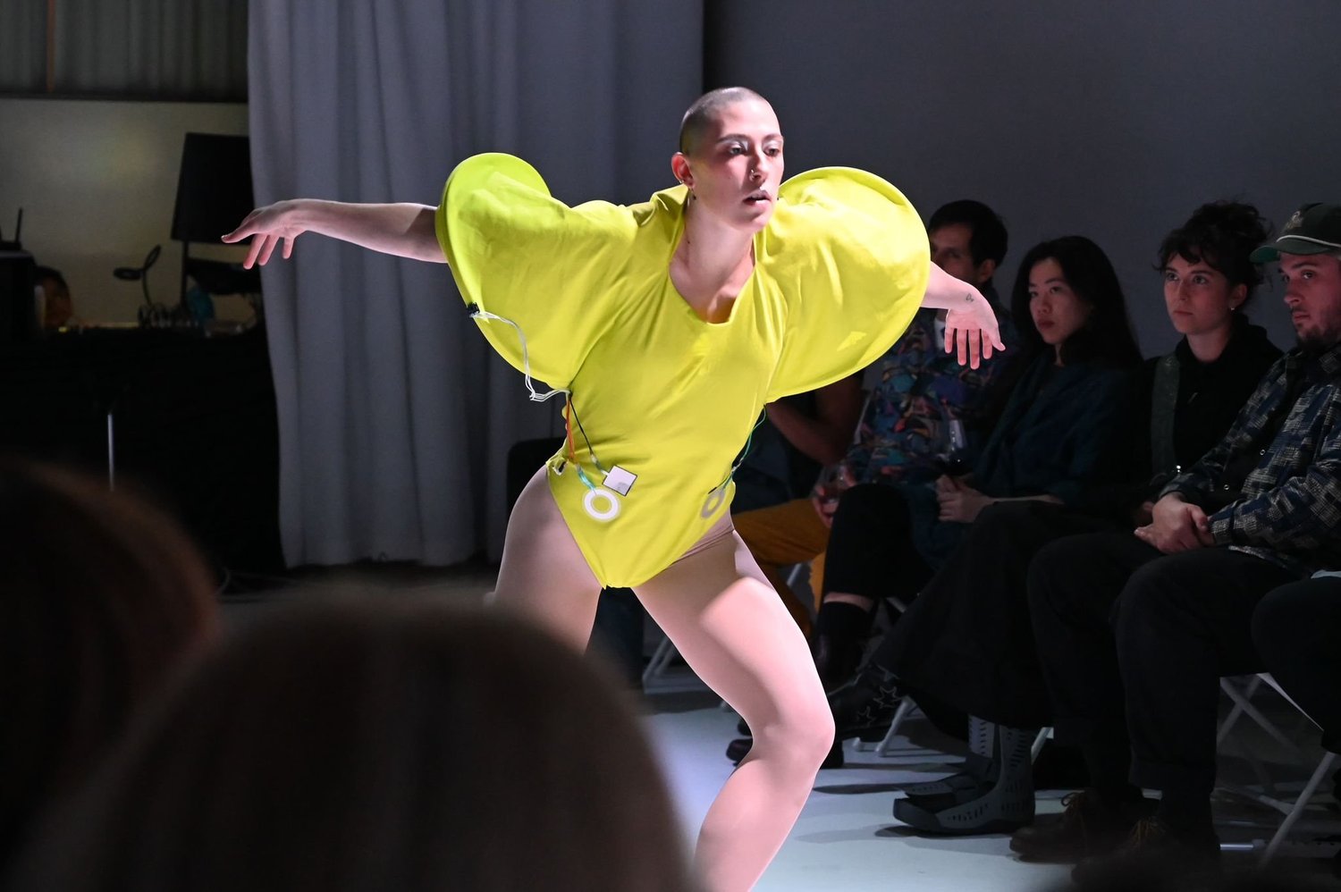 Yellow sculptural wearable instrument in performance.